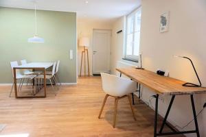 uma sala de estar com uma mesa e uma cadeira branca em Apartment - Neu, modern, gemütlich, eigener Parkplatz em Colónia