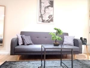 ein Wohnzimmer mit einem blauen Sofa und einem Tisch in der Unterkunft Apartment - Neu, modern, gemütlich, eigener Parkplatz in Köln