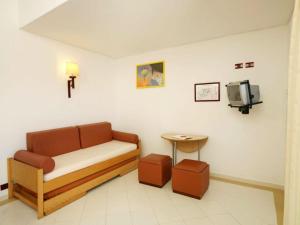a waiting room with a couch and a tv at Hotel Apartamento Do Golfe in Vilamoura