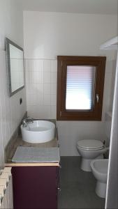 ein Badezimmer mit einer Badewanne, einem WC und einem Waschbecken in der Unterkunft Da nonna Pina in Cossogno
