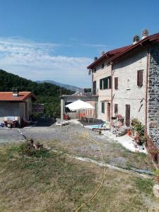 un edificio con patio e ombrellone bianco di Al Mostarolo a Berceto