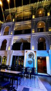 a building with tables and chairs in front of it at Le Maroc Hotel Patong in Patong Beach