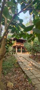 a stone walkway leading to a building in a forest at TREKKING TRAILS ECO STAY in Kalpetta