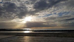 a sun setting over the ocean on a beach at THAT'S AMORE FIUMICINO Airport in Fiumicino