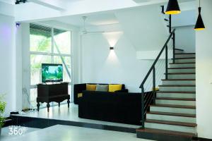 a living room with a staircase and a couch at Villa 360 in Talpe