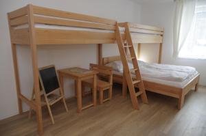 sypialnia z 2 łóżkami piętrowymi i biurkiem w obiekcie Apartmá 11 Deštné v Orlických horách w mieście Deštné v Orlických horách