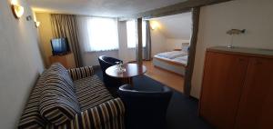 a hotel room with a couch and a bed at Hotel zur Krone in Hameln