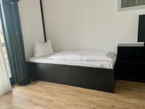 een klein bed in een kamer met een zwart frame bij Hotel My Schildow in Schildow