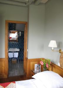 a bedroom with a bed and a bathroom with a sink at La Maison De Lucie in Honfleur