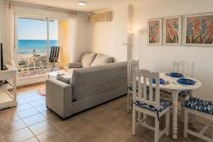 un soggiorno con divano e tavolo di APARTAMENTO EN PRIMERISIMA LINEA DE PLAYA n 10 a Playa de Xeraco