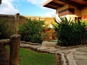 un jardín con un camino de piedra frente a una casa en Elegant Villa in La Fortuna with spacious backyard plus very private pool & parking en Fortuna