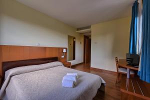 Un dormitorio con una cama con dos toallas encima. en Hotel Ibaigune, en Murueta