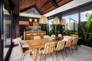 - une salle à manger avec une table et des chaises en bois dans l'établissement Shanti Sawah Ubud Villa, à Ubud