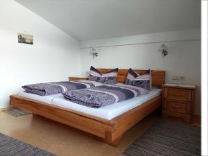 1 dormitorio con 1 cama de madera y 2 almohadas en Haus Moritz, en Nauders