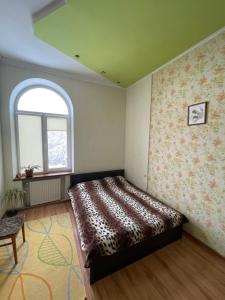 リヴィウにあるSoborna Comfort Placeのベッドルーム1室(ベッド1台、アーチ型の窓付)