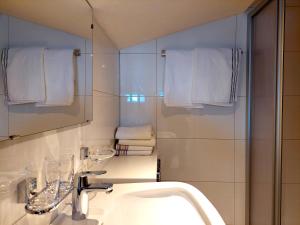 ein Badezimmer mit Waschbecken, Spiegel und Handtüchern in der Unterkunft Haus Moritz in Nauders + 14 Fotos