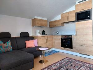 ein Wohnzimmer mit einem Sofa und einer Küche in der Unterkunft Haus Moritz in Nauders