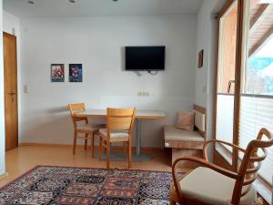 a dining room with a table and chairs and a tv at Haus Moritz in Nauders