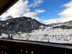 Blick auf ein schneebedecktes Bergdorf aus dem Fenster in der Unterkunft Haus Moritz in Nauders