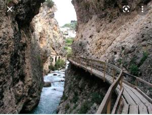a bridge over a river in a rocky canyon at Apartamento rural castril in Castril +16 photos