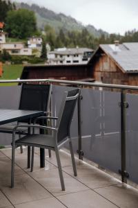 una mesa y sillas en la parte superior de un balcón en Zillertal Juwel, en Fügen