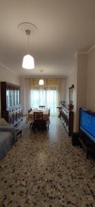 un ampio soggiorno con tavolo e televisore di Sweet home in Ostia a Lido di Ostia Altre 7 foto