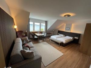 a living room with a couch and a bed at Landhotel Grünberg am See in Gmunden