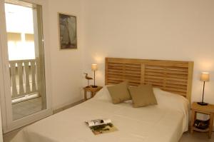 - une chambre avec un grand lit blanc et une fenêtre dans l'établissement Lagrange Vacances - Villa d'Este, à Arcachon