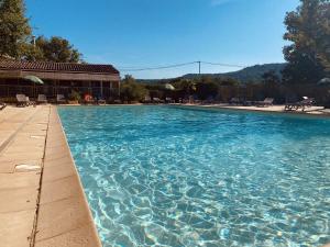 uma grande piscina com água azul em Domaine Les Chênes Blancs em Saint-Saturnin-dʼApt