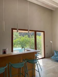 a kitchen with a bar with chairs and a window at Chiusa Di Carlo Agriturismo in Avola