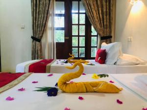 a hotel room with two beds with flowers on the floor at Grand freedom in Sigiriya