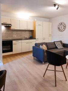 un soggiorno con divano blu e una cucina di Den 1 Hengelhoef ad Aan de Wolfsberg
