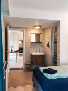 a bathroom with a bed and a sink in a room at Den 1 Hengelhoef in Houthalen-Helchteren