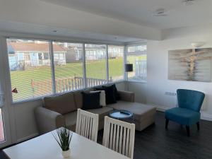 a living room with a couch and a table and chairs at Surfs Up Lodge - Westward Ho! in Westward Ho