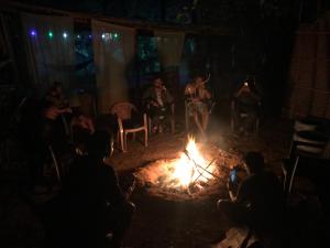 um grupo de pessoas sentadas à volta de uma fogueira em Tusker Tribe Hostel em Gokarna