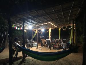 a group of people sitting in a hammock at night at Tusker Tribe Hostel in Gokarna