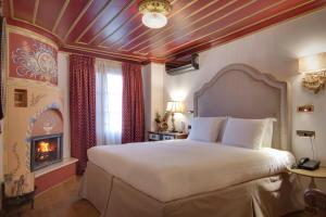 a bedroom with a large bed and a fireplace at ARCHONTARIKI Historic Boutique Hotel in Ioannina