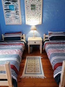 Habitación con 2 camas y mesa con lámpara. en The Gem sea facing free standing holiday house solar power, en Jeffreys Bay