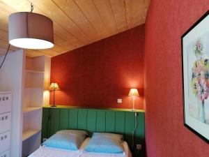 1 dormitorio con 1 cama verde y 2 almohadas en Gîte Le Marronnier en Ganac