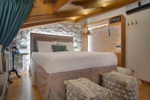 1 dormitorio con 1 cama grande y 2 sillas en ARCHONTARIKI Historic Boutique Hotel, en Ioannina