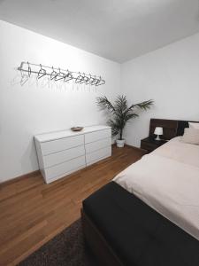 sypialnia z białym łóżkiem i białą komodą w obiekcie Eine schöne Wohnung im Herzen von Basel. w Bazylei