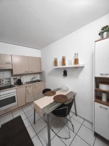 a small kitchen with a table and a refrigerator at Eine schöne Wohnung im Herzen von Basel. in Basel