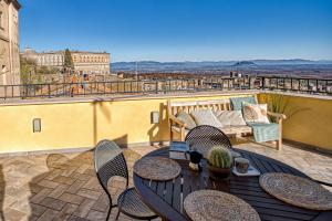 a patio with a table and chairs on a balcony at Casa Checca appartamenti per vacanze in Caprarola