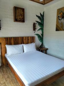 a bed in a room with a white mattress at Suites by Eco Hotel El Nido in El Nido