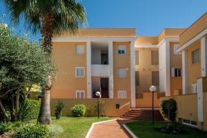 un gran edificio de apartamentos con palmeras en un patio en APARTAMENTO Nat EN PRIMERA LINEA DE PLAYA, en Playa de Xeraco