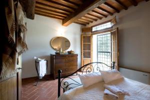 1 dormitorio con cama, espejo y tocador en Poggio di San Biagio, en Cantagrillo