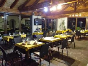 a restaurant with yellow tables and chairs in a room at Landhaus Weingut in Cornaiano