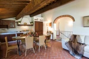 cocina y sala de estar con mesa y sillas en Poggio di San Biagio, en Cantagrillo