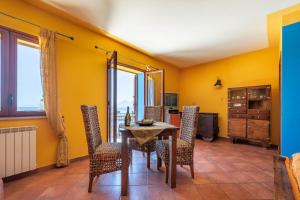 une salle à manger avec des murs jaunes, une table et des chaises dans l'établissement Stenopus Greco Casa per AFFITTI TURISTICI, à Santa Flavia