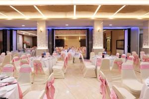 a banquet hall with white tables and white chairs at Southern Airport Hotel Hatyai in Hat Yai +111 photos